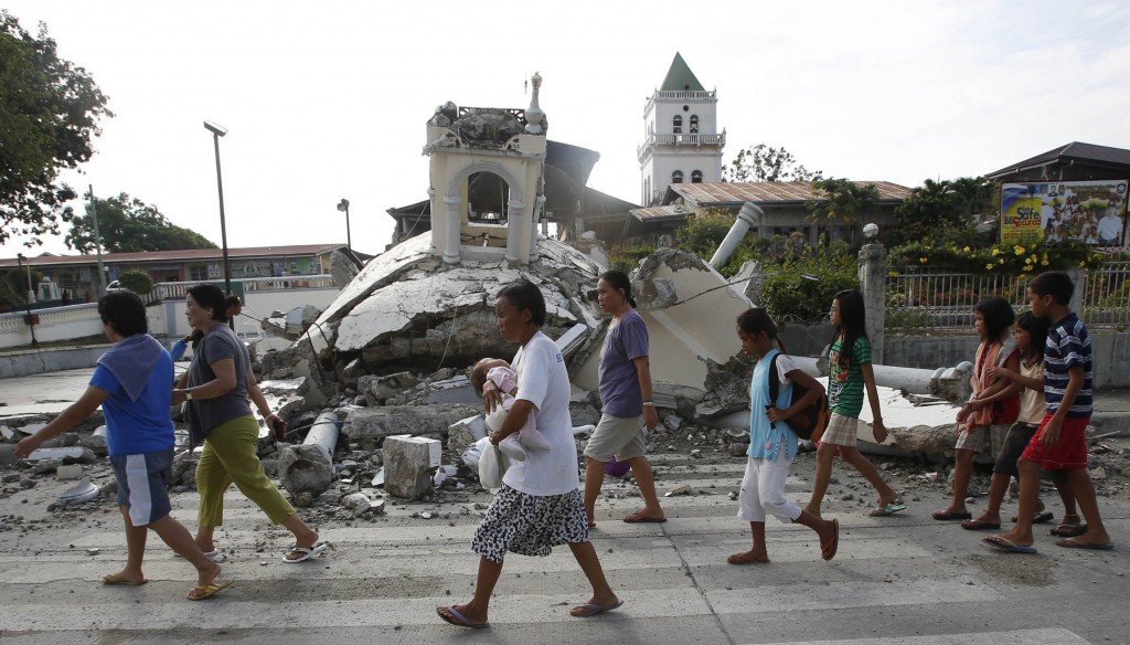Residents walk past a destroyed church in Bohol Oct. 16, a day after a magnitude 7.1 earthquake struck central Philippines. PHOTO: CNS/Erik De Castro, Reuters