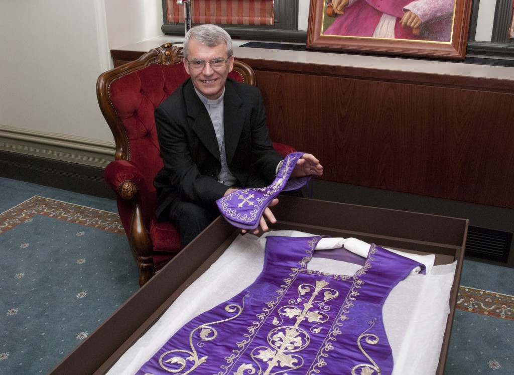 Archbishop Timothy Costelloe SDB examines the historic vestments in his Perth office. Made at the Royal Workshop in Spain in the 1830s, the vestments are thought to have been used by Archbishop Costelloe’s predecessor, Bishop Jose Maria Serra OSB. PHOTO: Robert Hiini