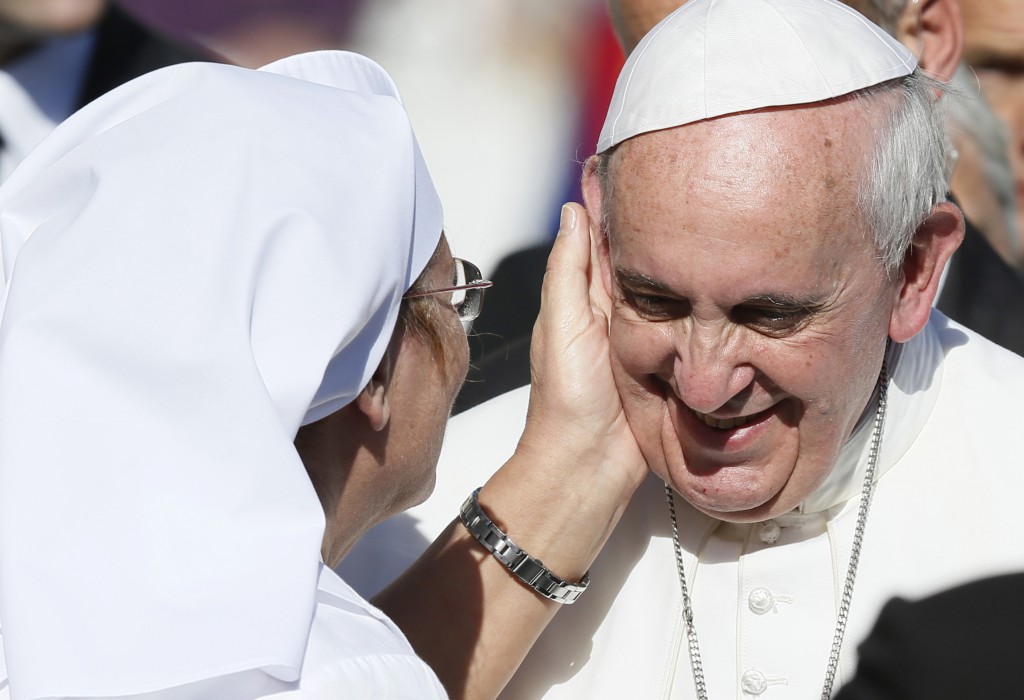 A caregiver accompanying a sick person greets Pope Francis on Nov. 6 during his general audience in St. Peter's Square at the Vatican. PHOTO: CNS/Paul Haring