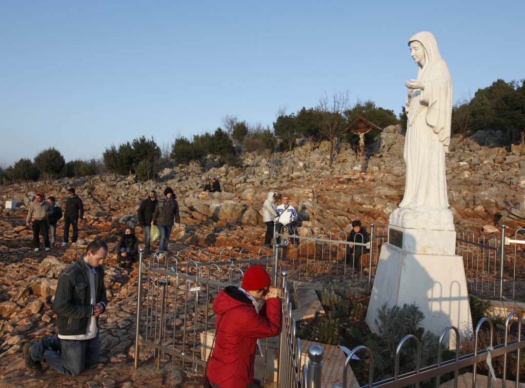 Pilgrims pray at a statue of Mary in 2011 on Apparition Hill in Medjugorje, Bosnia-Herzegovina. The site is where six village children first claimed to see Mary in June 1981. The Vatican ambassador to the United States reminded bishops of a doctrinal congregation ruling that it was not yet possible "to state that there were apparitions or supernatural revelations" by visionaries in Medjugorje. PHOTO: CNS/Paul Haring