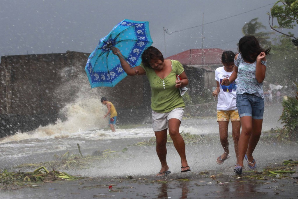 Residents in a town south of Manila flinch from wind and rain brought on by Typhoon Haiyan Nov. 8. The storm, possibly the most powerful ever to hit land, battered the central Philippines, forcing millions of people to flee to safer ground, cutting power lines and blowing apart houses. PHOTO: CNS/Charlie Saceda, Reuters