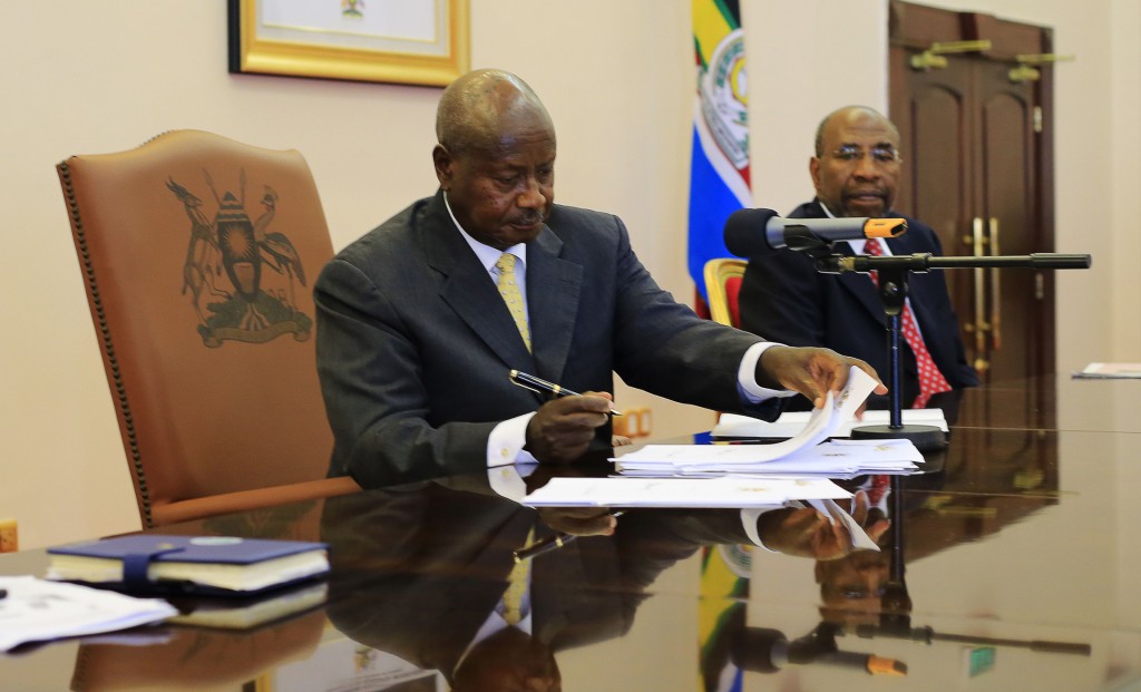 Uganda President Yoweri Museveni signs an anti-homosexuality bill into law in Entebbe Feb. 24. UgandaÕs Catholic bishops reaffirmed their opposition to homosexuality, but reserved judgment on the bill, which imposes harsh punishment for homosexual acts. PHOTO: CNS/James Akena, Reuters