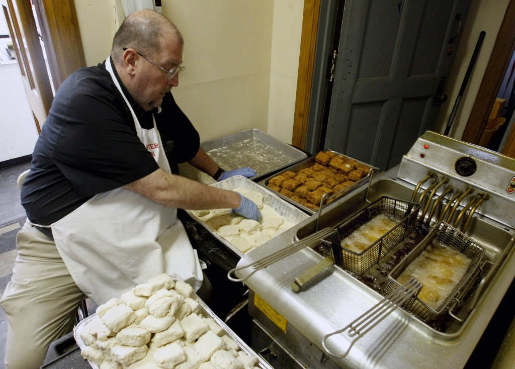 Mgr Tim Stein, pastor of St Mary’s Parish in the US, rolls fish in batter during a fish fry at the parish hall. PHOTO: CNS/Bob Roller