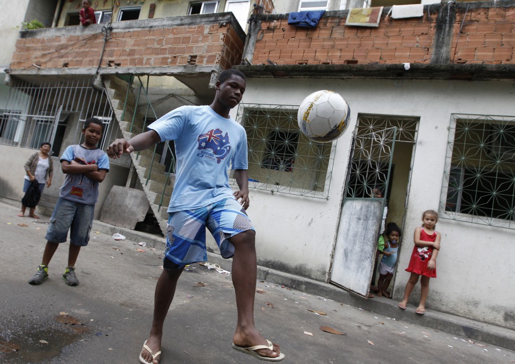A boy shows his soccer skills to journalists on July 23 visiting the Varginha section of the Manguinhos complex of slums in Rio de Janeiro, Brazil. PHOTO: CNS/Paul Haring