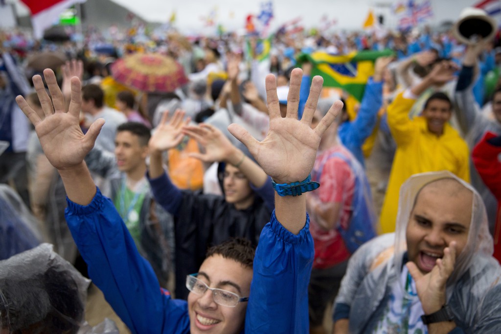 Pilgrims wave to television cameras on  July 23 during the opening Mass of World Youth Day in Rio de Janeiro. PHOTO: CNS/Tyler Orsburn