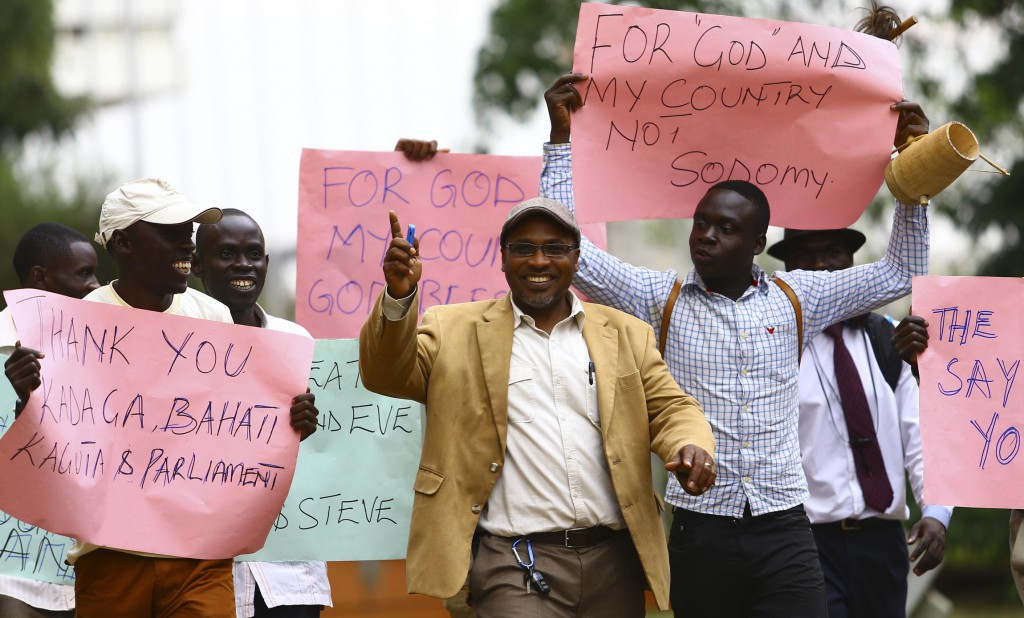 Men carry signs in Kampala, Uganda, Feb. 24, as they celebrate a new anti-homosexuality law. Uganda’s Catholic bishops reaffirmed their opposition to homosexuality, but reserved judgment on the bill, which imposes harsh punishment for homosexual acts. PHOTO: CNS/Edward Echwalu, Reuters