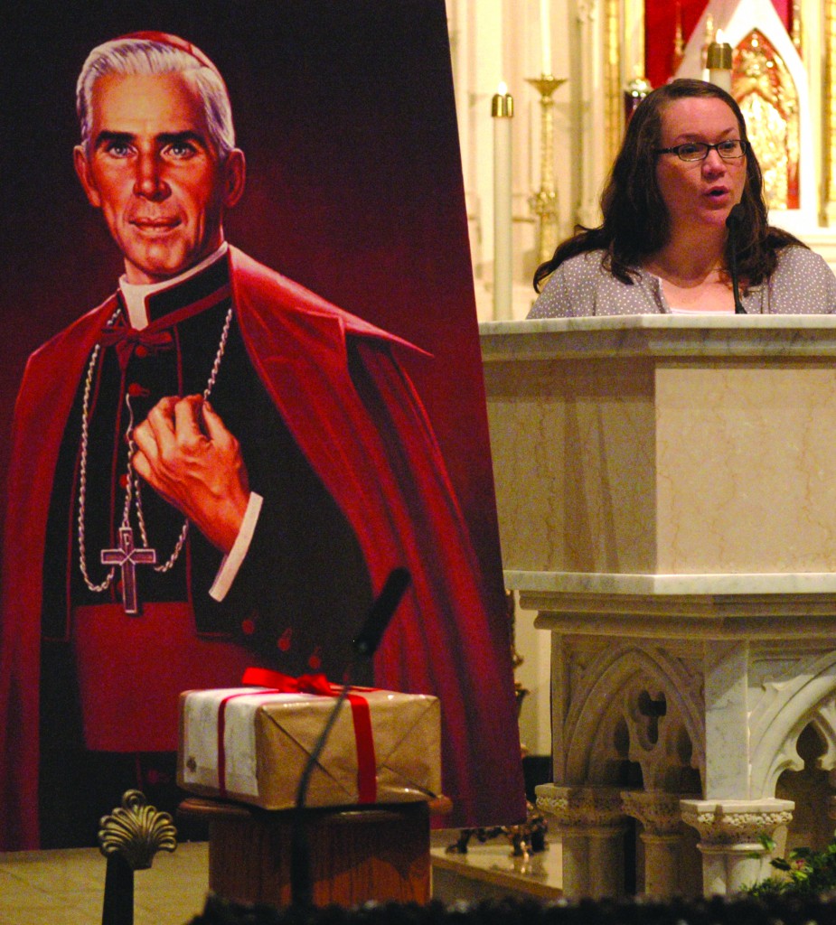 With evidence of her son’s alleged miraculous healing boxed and sealed in front of a portrait of Archbishop Fulton Sheen, Bonnie Engstrom gives a reading at a 2011 Mass at St Mary’s Cathedral in Peoria, Illinois. Photo: CNS