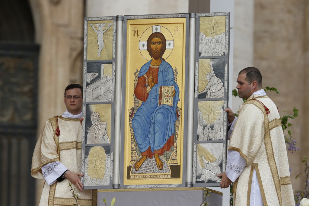Altar servers unveil an image of Jesus to signify the resurrection as Pope Francis celebrates Easter Mass in St Peter's Square at the Vatican March 31. (CNS photo/Paul Haring) (March 31, 2013).