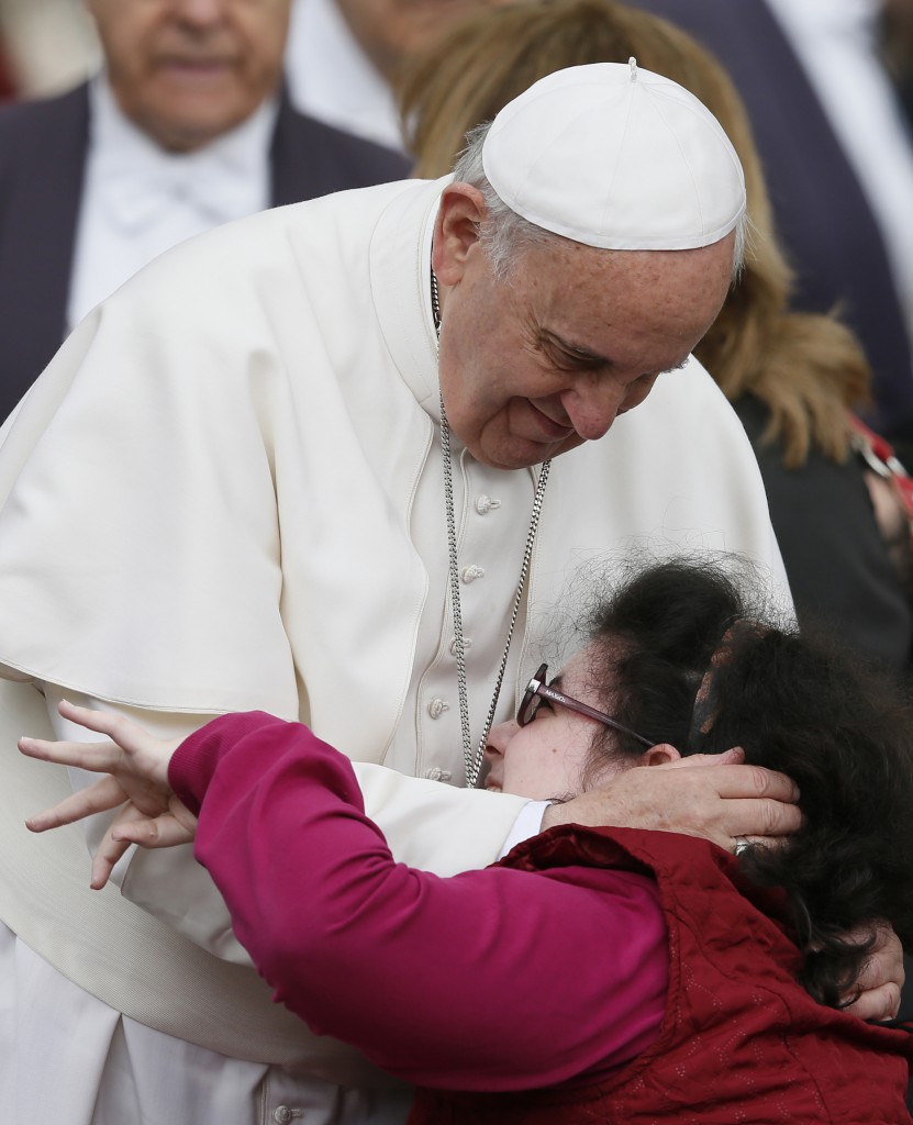 Pope Francis embraces a woman as he greets disabled people during his general audience on  April 9 in St. Peter's Square at the Vatican. PHOTO: CNS/Paul Haring