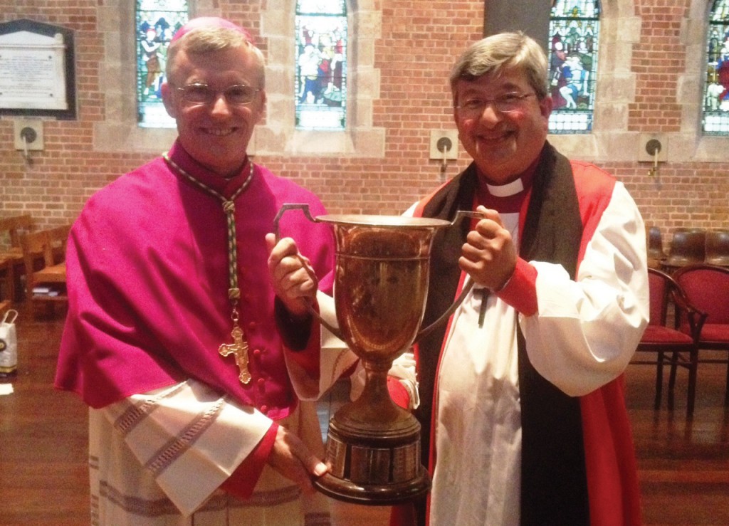 Catholic Archbishop Timothy Costelloe SDB, left, and Anglican Archbishop Roger Herft with the ‘Archbishop’s Cup’ which they blessed on April 6.