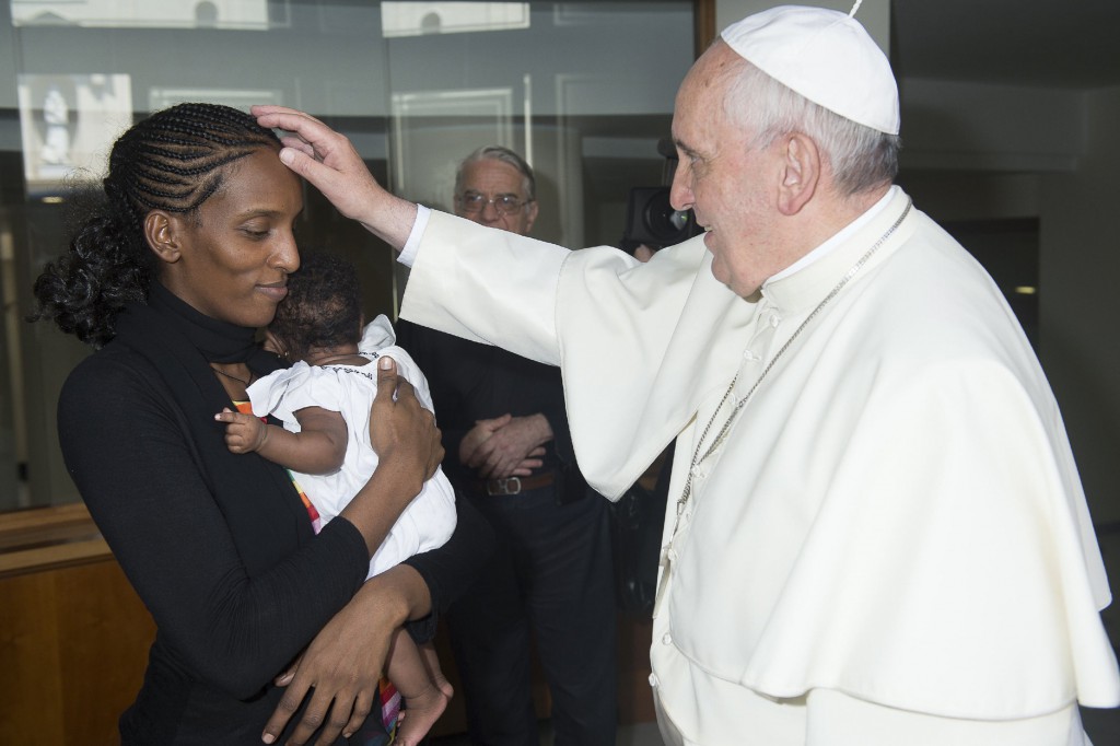 Pope Francis blesses Mariam Ibrahim of Sudan during a private meeting at the Vatican July 24. The Sudanese woman, who was spared a death sentence for converting from Islam to Christianity and then was barred from leaving Sudan, flew into Rome July 24 in an Italian government plane. PHOTO: CNS/L'Osservatore Romano via Reuters