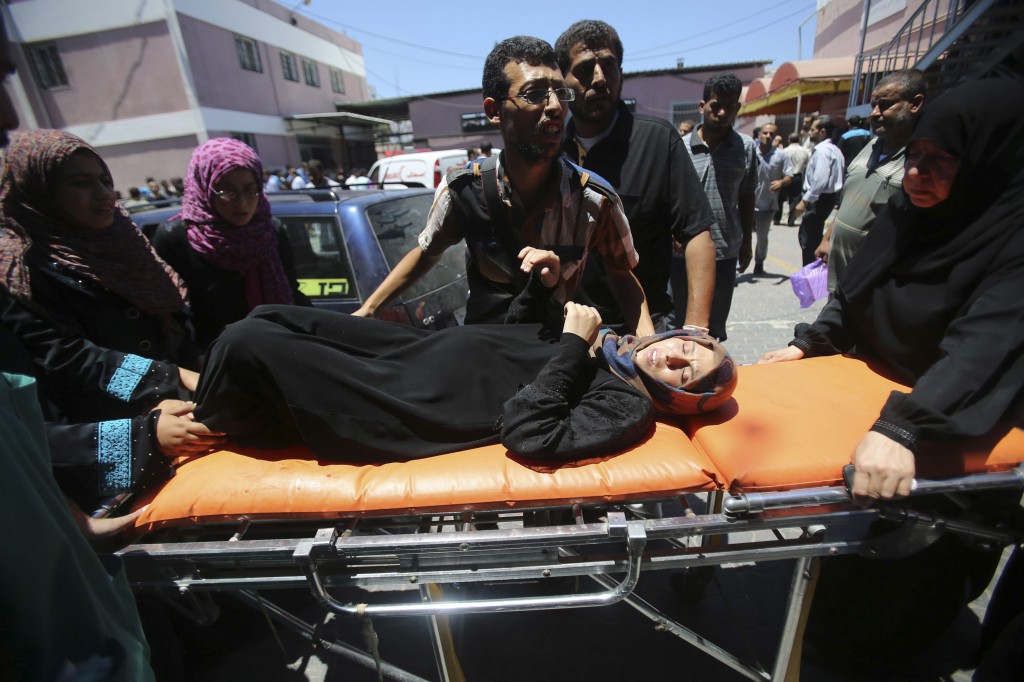 Palestinians wheel a stretcher transporting a woman, who medics said was wounded by an Israeli airstrike, to a hospital in Khan Younis, Gaza Strip July, 24. Fighting pushed the Palestinian death toll over 700. PHOTO: CNS/Ibraheem Abu Mustafa, Reuters