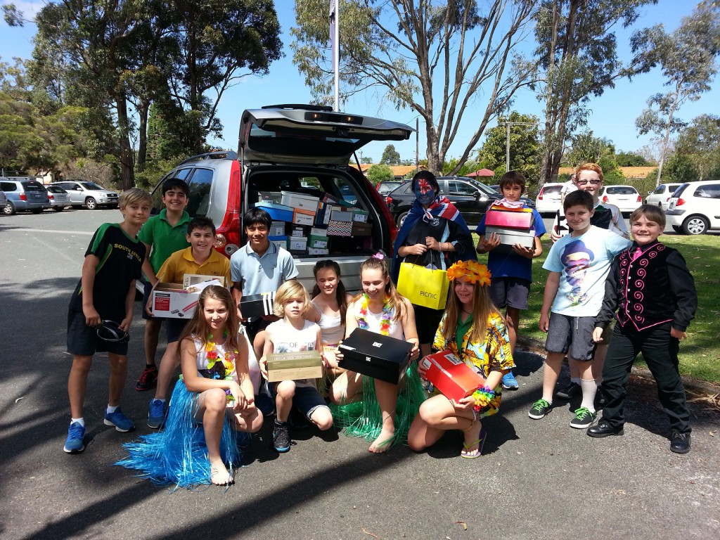 Bull Creek Primary School students help load the Sohs' car with Shoeboxes whcih were collected by the school.
