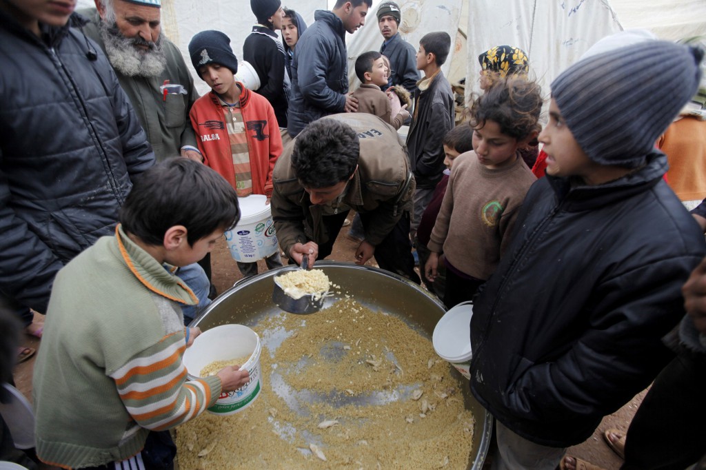Syrian refugees collect food at the Bab Al-Salam refugee camp in Azaz, near the Syrian-Turkish border, March 14. PHOTO: CNS/Hamid Khatib, Reuters