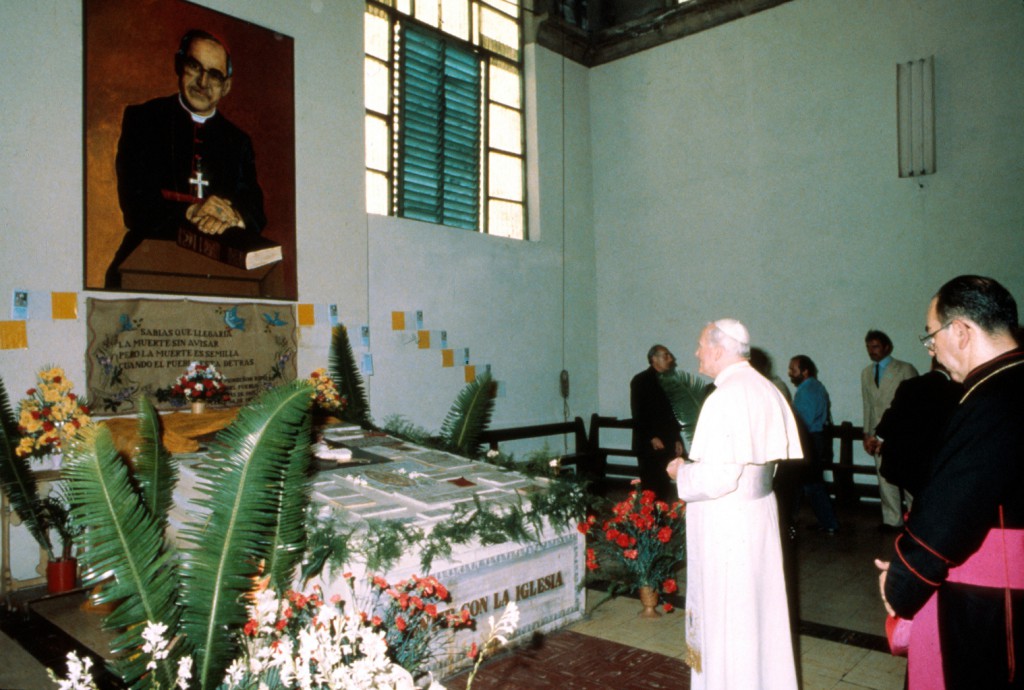 St. John Paul II prays before the tomb of Archbishop Oscar Romero in the San Salvador cathedral during his 1983 visit to the city. PHOTO: CNS/Giancarlo Giuliani