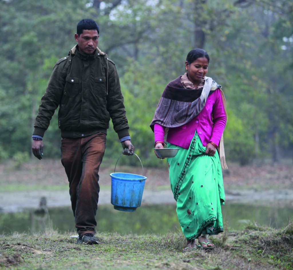 Sarita and Fish Technician Tula Ram Dagaura walk to the pond to tend to the fish. PHOTO: Stephen Kadlec