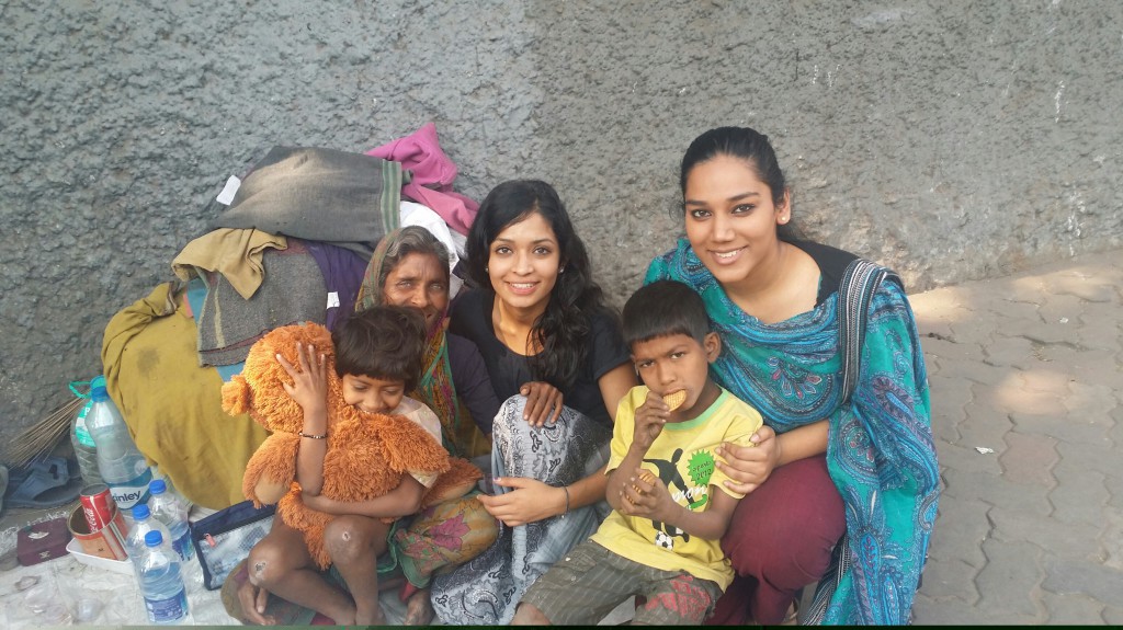 Michelle Stephen (left) and Syona Fernandez with mother and children living on Kolkata streets. (Young girl with teddy bear given as present.) PHOTO: Supplied