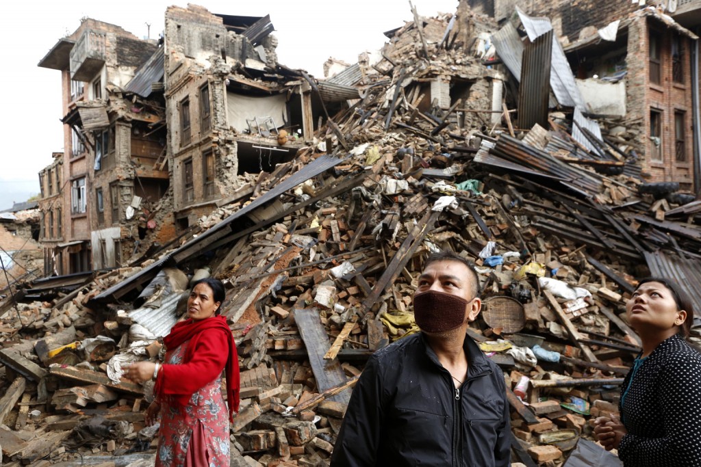 Survivors look at destroyed buildings April 27 following an earthquake in Bhaktapur, Nepal. More than 3,600 people were known to have been killed and more than 6,500 others injured after a magnitude-7.8 earthquake hit a mountainous region near Kathmandu April 25.  PHOTO: CNS/Abir Abdullah, EPA