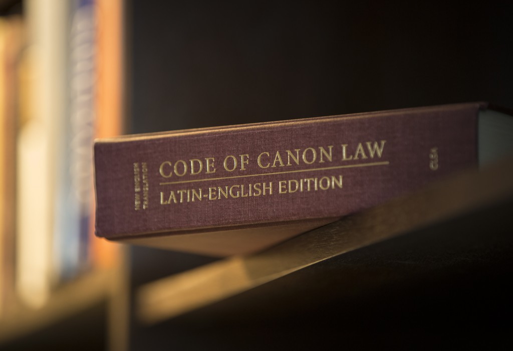 A Latin-English edition of the Code of Canon Law is pictured on a bookshelf.  PHOTO: CNS
