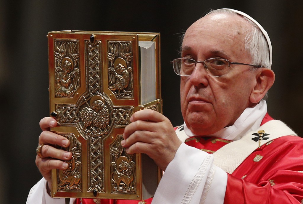 Pope Francis raises the Book of the Gospels during Pentecost Mass in St. Peter's Basilica at the Vatican May 24. PHOTO: CNS/Paul Haring