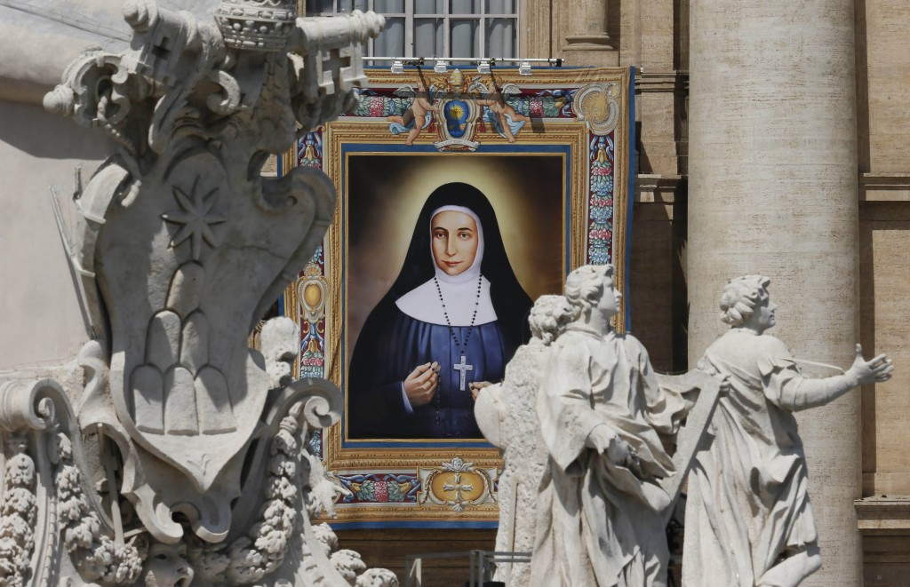 A banner showing new Saint Marie-Alphonsine hangs from the facade of St. Peter's Basilica as Pope Francis celebrates the canonization Mass for four new saints in St. Peter's Square at the Vatican May 17. PHOTO: CNS/Paul Haring