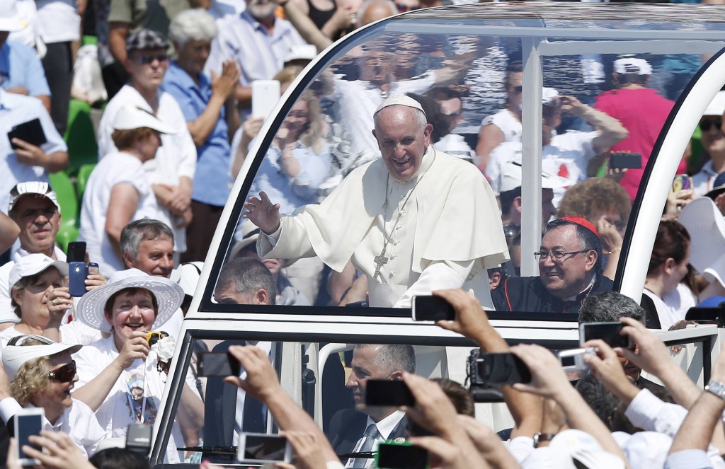 Pope Francis greets the crowd as he arrives to celebrate Mass at Kosevo stadium in Sarajevo, Bosnia-Herzegovina, June 6. Also in the Popemobile is Bosnian Cardinal Vinko Puljic of Sarajevo. The Pope was making a one-day visit to Bosnia-Herzegovina to encourage a minority Catholic community in the faith, and to foster dialogue and peace in a nation still largely divided along ethnic lines. PHOTO: CNS/Paul Haring