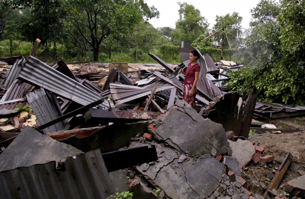 A woman stands among the rubble of a destroyed building hit by tornado in Sittwe, Myanmar on 27 July. PHOTO: CNS
