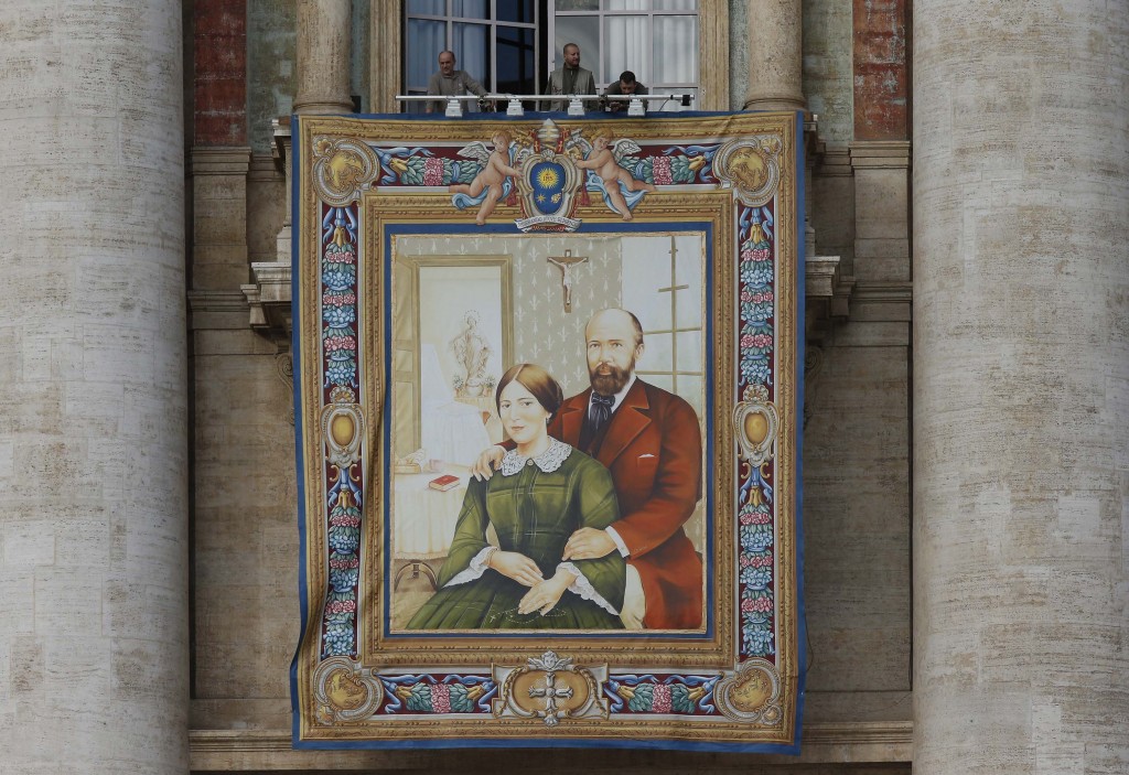 Workers prepare a banner of Louis and Marie-Azelie Guerin Martin, the parents of St Therese of Lisieux, on the facade of St Peter's Basilica at the Vatican on 16 October in advance of their canonisation. PHOTO: CNS/Paul Haring