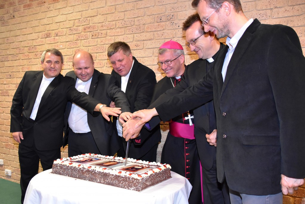 Archbishop Timothy Costelloe, centre, with, from left Fr Leonard SDS, Fr Karol SDS, Fr Bronek SDS, Fr Irek SDS and Fr Chris SDS, from St Anthony’s Parish Greenmount, cutting the cake to celebrate the installation of the relics of St Anthony of Padua, John Paul II and St Mary MacKillop. Photo: Supplied.