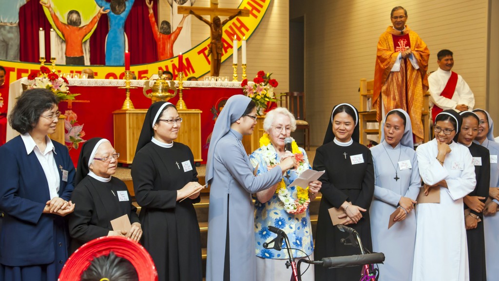 Sister Patricia Byrne expresses her gratitude and love to the Vietnamese Catholic Community after receiving a gift and being adorned with flowers. Photo: Supplied