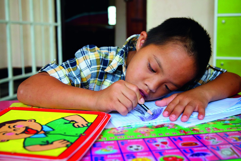 Hum Noy concentrating hard during a lesson. “Hum Noy is learning how to follow instructions and say the names of his teachers and friends,” says his mother, Duangmala. Photo: Richard Wainwright