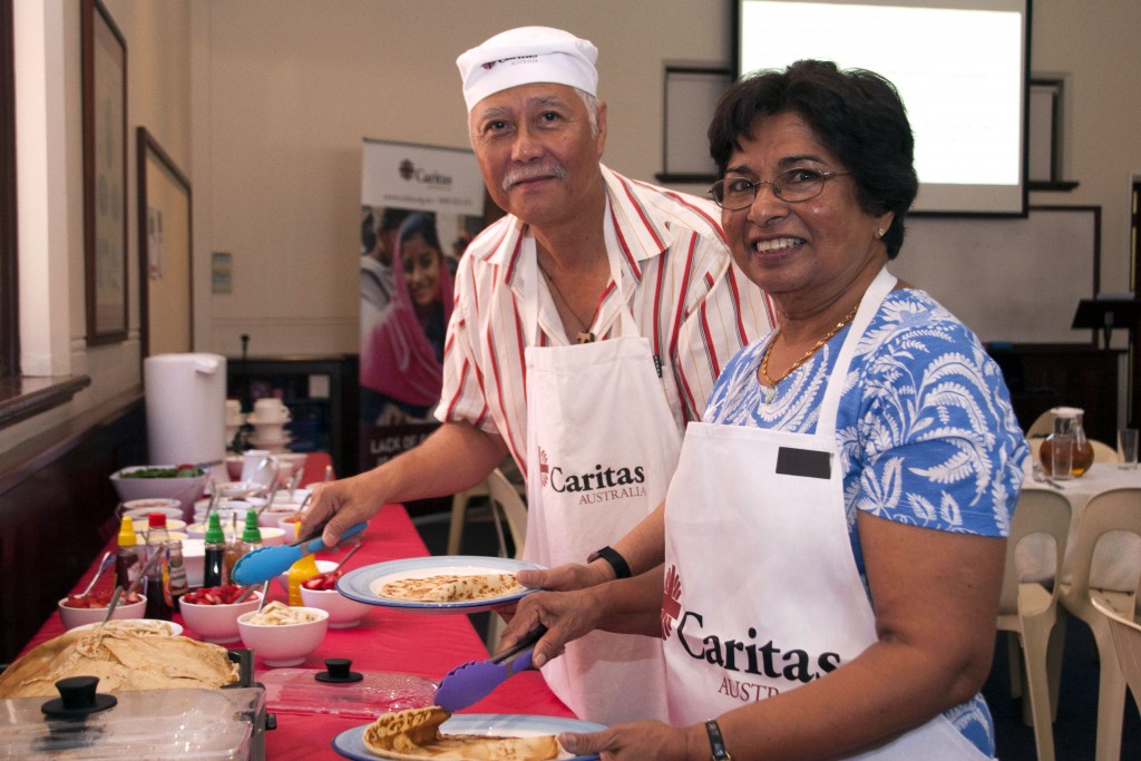 Cooks responsible for preparing the pancake lunch, Dominic Chew and Margaret Yesuratnam, help themselves to the fruits of their labour at the Caritas Shrove Tuesday pancake lunch. Photo: Marco Ceccarelli.