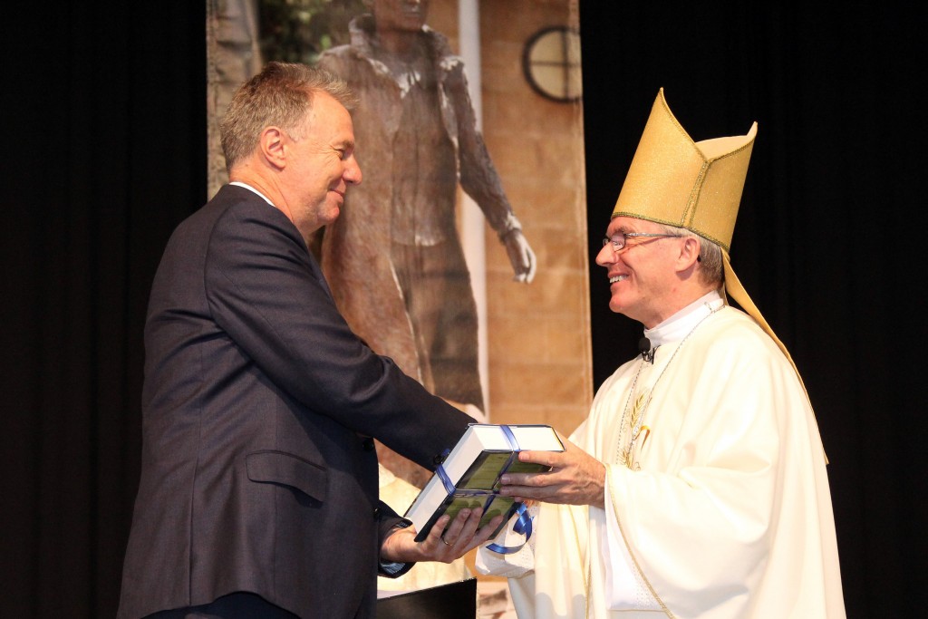 The new principal of John XXIII College in Claremont, Mr Robert Henderson, receives The New Jerusalem Bible as a gift from Archbishop Timothy Costelloe SDB at the opening college Mass on Thursday, 4 February 2016. Photo: Supplied