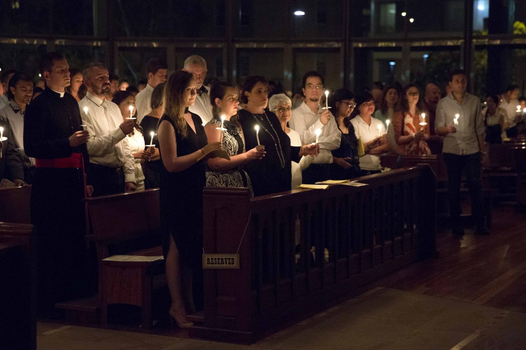 The congregation hold their candles during the liturgy of light at the commencement of the Easter Vigil at St Mary’s Cathedral on 26 March 2016. Photo: Ron Tan.