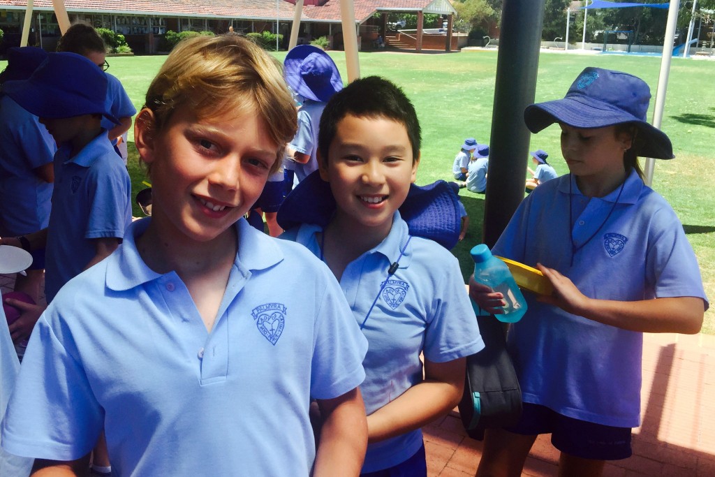 Our Lady of Fatima Primary School students Jude Foss and Kieren Nguyen are happy to line up to receive rice for lunch in exchange for a gold coin donation to Project Compassion. Photo: Supplied