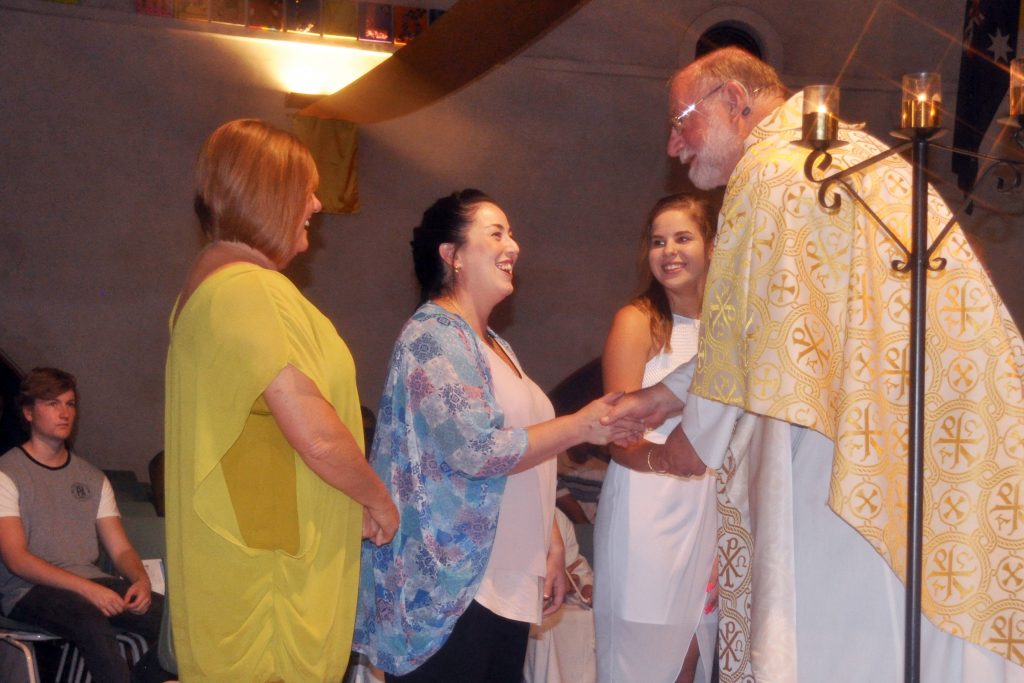 Amanda Dillon is congratulated by Ballajura Parish Priest Fr John Jegorow during the Easter Vigil at Mary MacKillop Catholic Church. Photo: Supplied