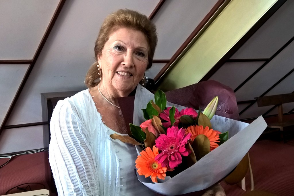 North Beach parishioner Mary Croft receives flowers recognising her 40 years of service after singing at Mass for the final time on Easter Sunday. Photo: Supplied