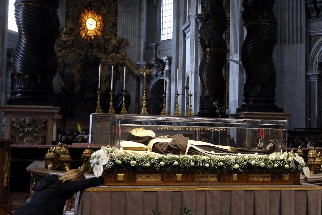 A woman prays at the glass case containing the body of St Padre Pio in St Peter's Basilica at the Vatican on 6 February 2016. The uncorrupted body of Padre Pio was brought to Rome at the request of Pope Francis for the Year of Mercy. Photo: CNS/Paul Haring
