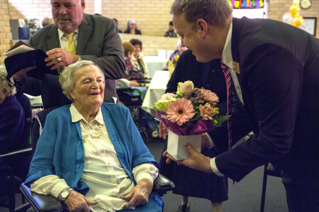 Sheila Stade, aged 101, receives flowers from City of Stirling Councillor David Michael, as City of Stirling Mayor Giovanni Italiano prepares to present her with a plaque. Photo: Rachel Curry