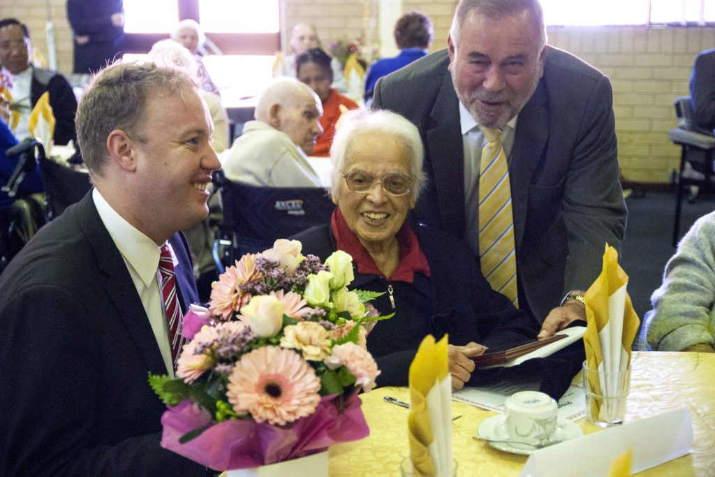City of Stirling Councillor David Michael and Mayor Giovanni Italiano present 100-year-old Linda Baptist with flowers and a plaque during the celebration on Thursday, 25 August. Photo: Rachel Curry
