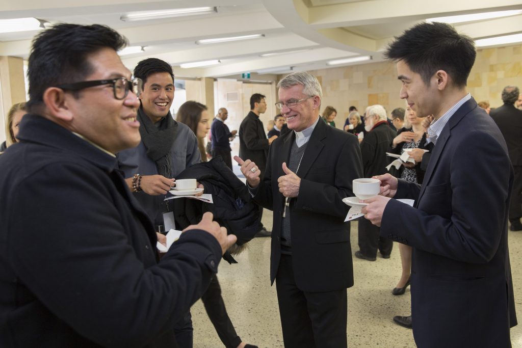 Archbishop Timothy Costelloe (second from right) shares a joke with Archdiocese of Perth agency staff at the morning tea following the Mass. Photo: Ron Tan