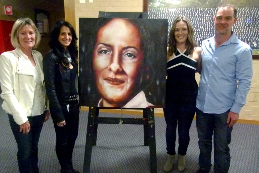 (Gail Park, Lisa Bowden, Angela Park, Brian Morison) (L-R) Old school friends and family of Felicity Park: Gail Park, artist Lisa Bowden, Angela Park and Brian Morison stand beside a portrait of Ms Park, who passed away in 2003. The artwork will soon feature as a memorial to Ms Park at Mater Dei College. Photo: Supplied