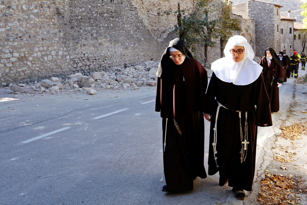 Nuns walk next to a partially collapsed wall on 30 October following an earthquake in Norcia, Italy. The earthquake reduced the Basilica of St Benedict to rubble. Photo: CNS/Remo Casilli, Reuters