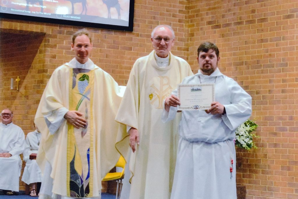 Fr Thomas Zureich with Thornlie Parish Priest Mgr Tim Corcoran presenting senior altar server Luke McLachlan with his certificate commemorating his 25 years of service as an altar server. Photo: Supplied