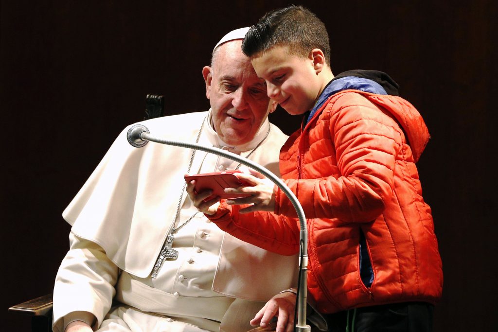 A boy takes a selfie with Pope Francis before celebrating Mass at St Mary Josefa Parish in Rome on February 19. Photo: CNS/Paul Haring
