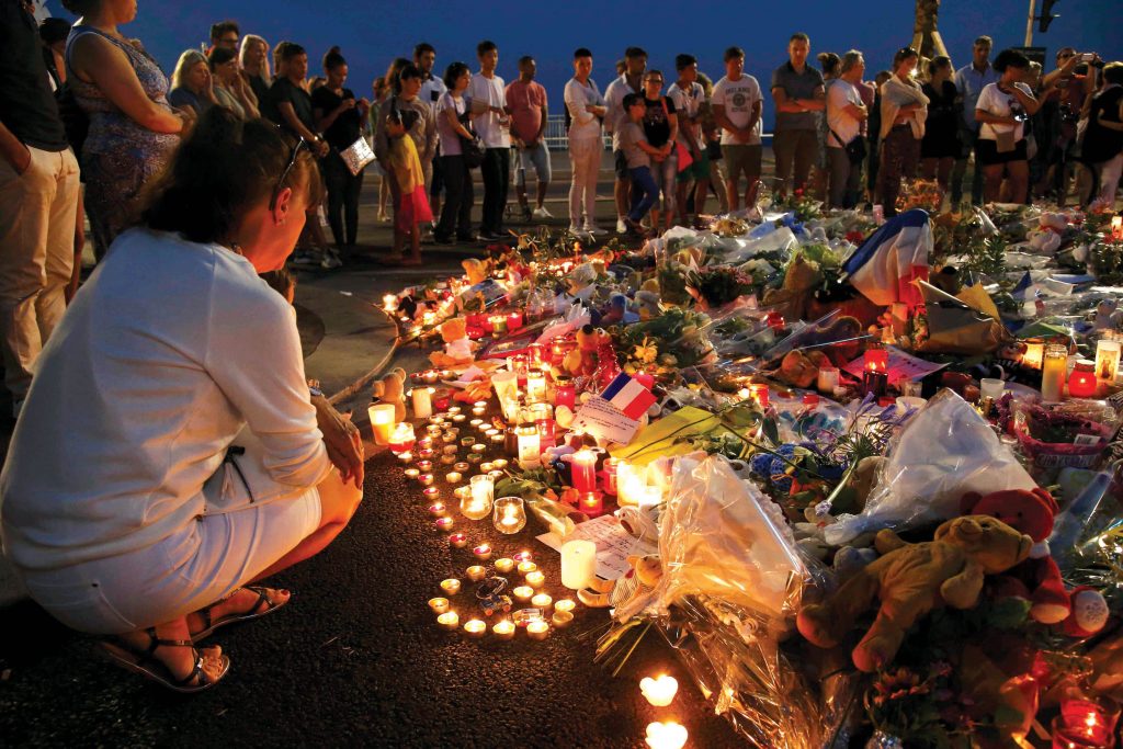 People gather around flowers and burning candles on 17 July 2016 to pay tribute to victims of the Bastille Day attack in Nice, France. In response to the attack, Pope Francis prayed that God may give comfort to grieving families and foil the plans of those who wish to harm others. Photo: CNS/Pascal Rossignol, Reuters