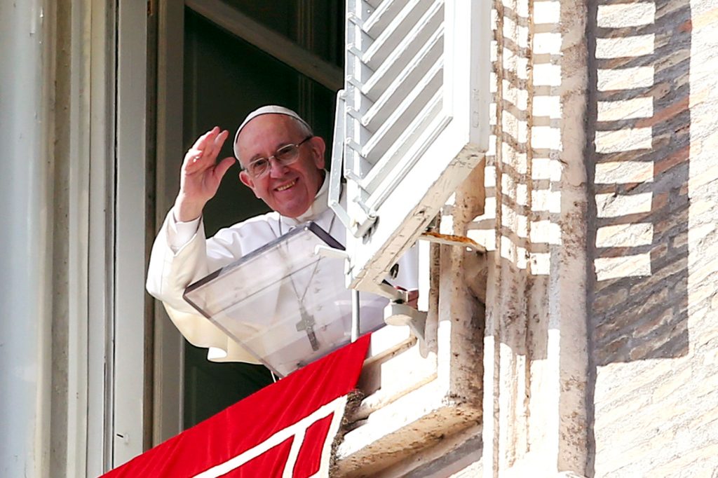 Pope Francis waves as he leads the Angelus from his studio overlooking St. Peter's Square at the Vatican. Photo: Alessandro Bianchi, Reuters