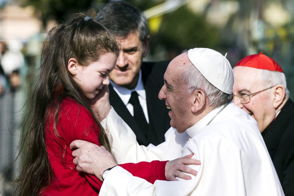 Pope Francis greets a girl during a 12 March visit to the Parish of St Magdalene of Canossa, Rome. Photo: CNS/Angelo Carconi, EPA