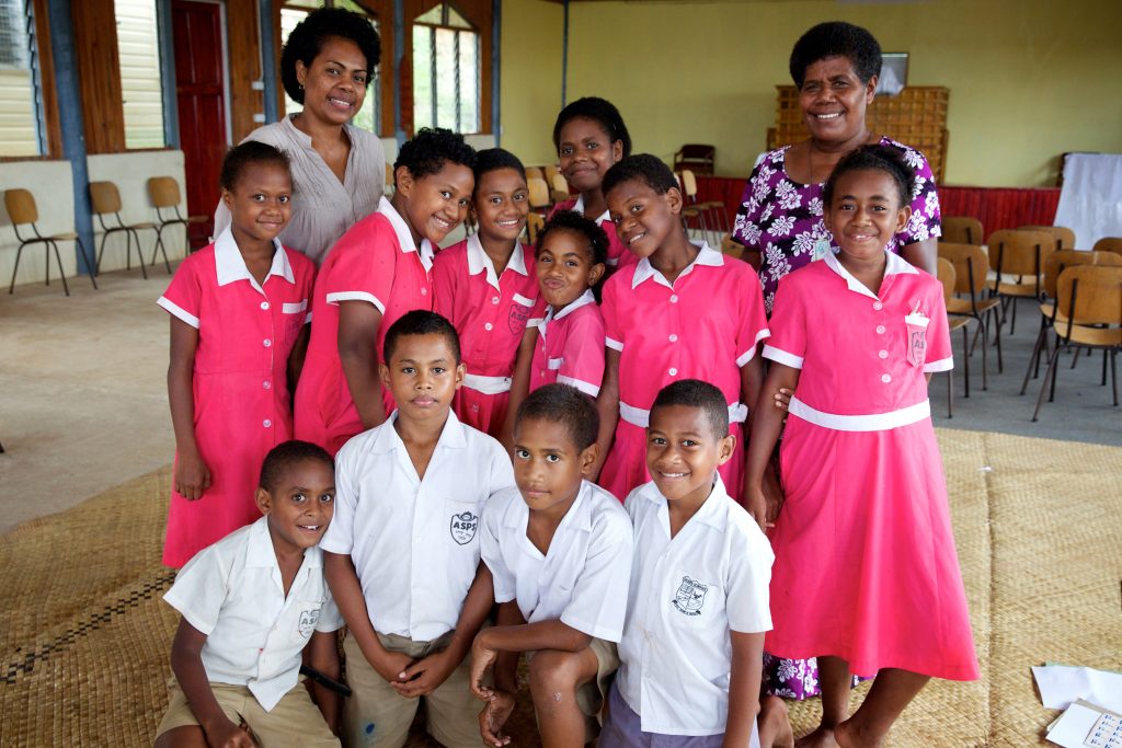 Children attending the Homework Centre run by The Peoples Community Network (PCN) in Jittu Estate, a settlement in Suva, are assisted by teachers Mrs Asenaca (left) and Maria Bereso. Richard Wainwright/Caritas Australia