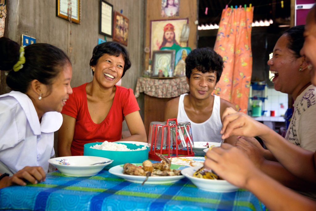 Dinia having lunch with her family at home. Photo: Richard Wainwright/Caritas Australia
